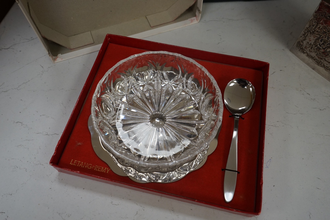 A George V silver cigarette box and assorted plated ware to include a cased cruet, a modern silver wine coaster and an embossed Dutch style tea caddy, largest 23cm wide. Condition - varies